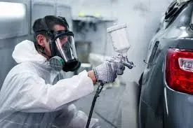 Collision repair painter refinishing a vehicle